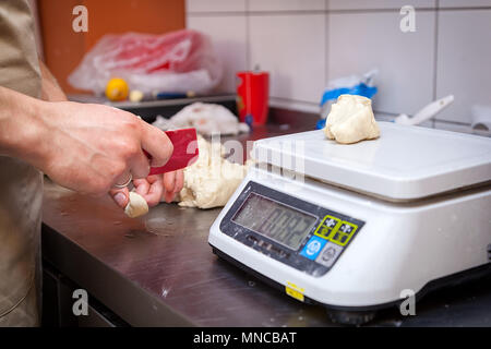 baker weighing bread dough on scale at bakery Stock Photo - Alamy