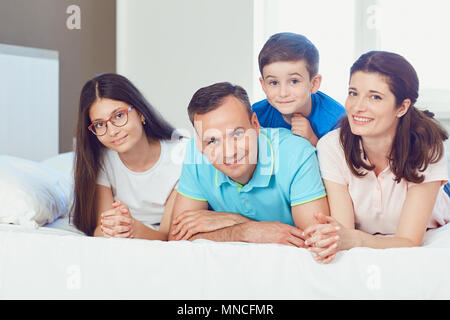Portrait of happy family lying in bedroom Stock Photo