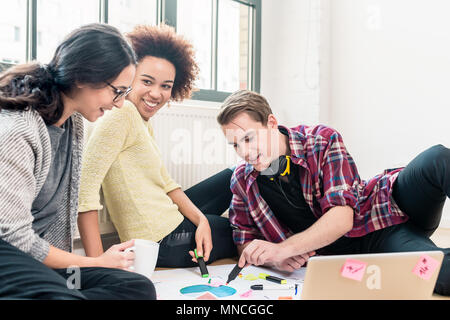 Three young creative employees working together on a project  Stock Photo