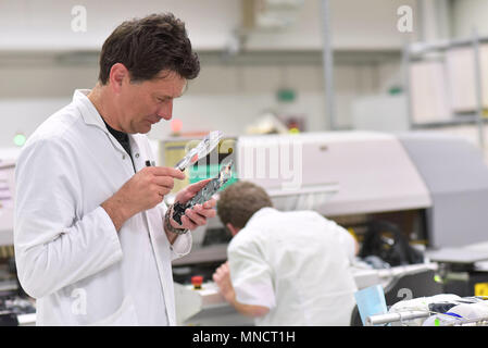 industrial factory for assembly of microelectronics - engineer controls the quality Stock Photo