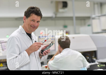 industrial factory for assembly of microelectronics - engineer controls the quality Stock Photo