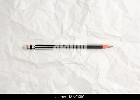 Put a pencil on crumpled paper background Stock Photo