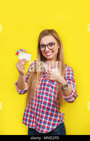 Young woman with card and flags of different speaking countries. Studio portrait of young beautiful female student Stock Photo