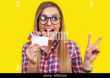 Young woman with card and flags of different speaking countries. Studio portrait of young beautiful female student Stock Photo