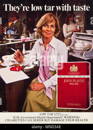 1980s original old vintage advertisement advertising John Player King Size Extra Mild low tar cigarettes by Royal Appointment with government health warning advert in English magazine circa 1980 Stock Photo