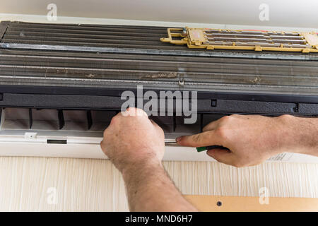 Male hands check and set up ac conditioner Stock Photo