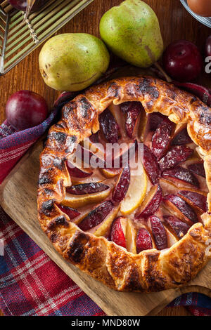 Galette with pears and plums. Rustic open pie. French cuisine Stock Photo