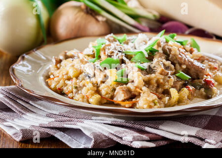 Risotto with champignon mushrooms, pork and parmesan. Italian cuisine