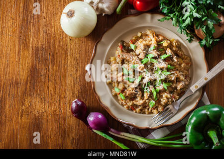 Risotto with champignon mushrooms, pork and parmesan. Italian cuisine. Top view