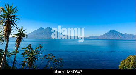 View from Lake Atitlan in the early morning, blue skys and clear water, beautiful magic lake with volcanos and indigenous people in the highland of Gu Stock Photo