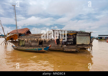 A typical wooden houseboat anchored in the floating village Chong Kneas on Tonle Sap Lake in Cambodia. Stock Photo