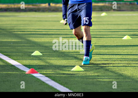 Soccer football players during the team training before the match. Exercises for football soccer youth team. Player exercises with ball and marker cones Stock Photo
