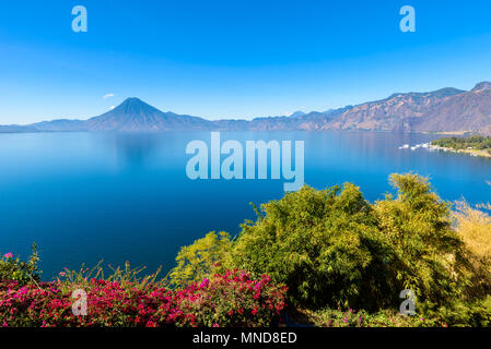 View from Lake Atitlan in the early morning, blue skys and clear water, beautiful magic lake with volcanos and indigenous people in the highland of Gu Stock Photo