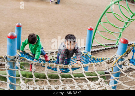 High angle view of boys climbing on net at playground Stock Photo