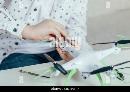 Midsection of boy adjusting drone at home Stock Photo