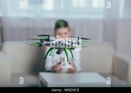 Boy flying drone in living room at home Stock Photo