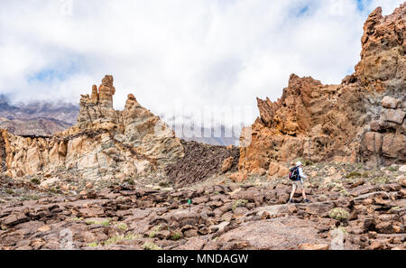 Walking though the eroded pinnacles of the Roques de Garcia in the Las Canadas caldera of Mount Teide on Tenerife in the Canary Islands Stock Photo