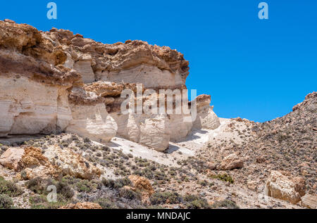 Cliffs of white and yellow layers of relatively soft pumice high on the Las Canadas caldera rim of Mount Teide on Tenerife in the Canary Islands Stock Photo