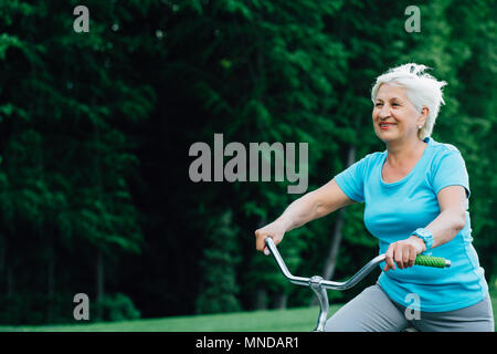 Happy senior woman cycling. Stock Photo