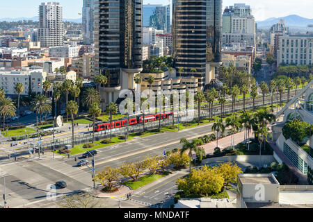 Morning Street - An aerial view of a red San Diego Trolley stopping at a station on East Harbor Drive in Marina District of Downtown San Diego, CA, US Stock Photo