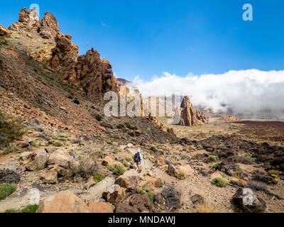 Female walker approaching striking rock formation The Cathedral an eroded volcanic plug at the Roques de Garcia on Mount Teide Tenerife Canary Islands Stock Photo