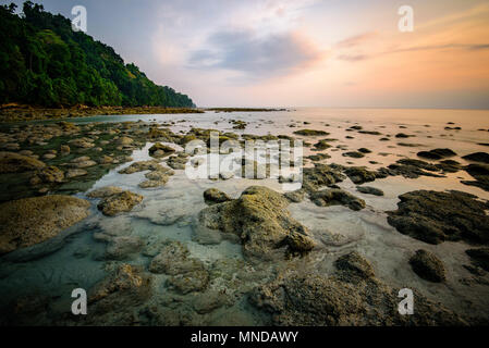 Rocks strewn around in shallow waters at Radhanagar beach in Havelock island in the Andaman and Nicobar archipelago, India. Stock Photo