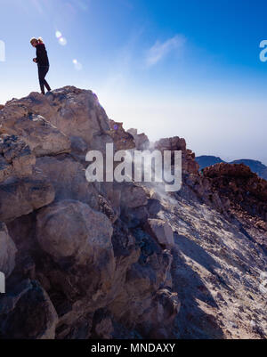 A female climber on the smouldering summit crater of active volcano Mount Teide at 3718 metres on Tenerife the largest of the Canary Islands Stock Photo