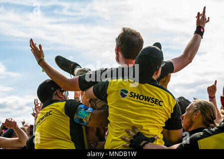 Male crowd surfer lifted from the music festival crowd by security Stock Photo