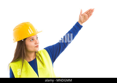 Young beautiful female architect or engineer pointing up with stretched arm as presenting concept isolated on white background Stock Photo