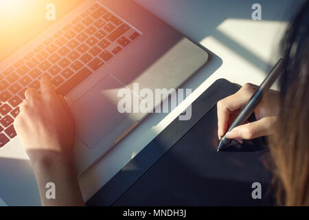 Close up view of graphic designer hand using digital tablet pen with sunlight.selective focus Stock Photo