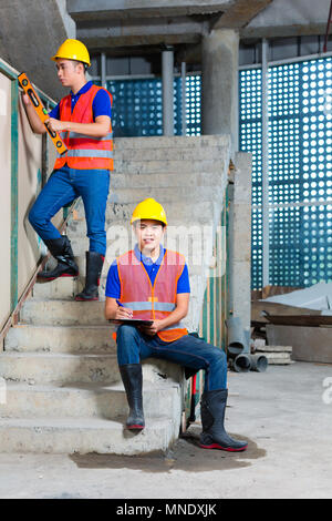 Asian workers on building or construction site walling Stock Photo