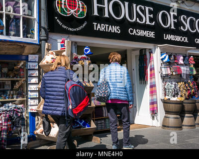 Royal Mile, Edinburgh, 16th May 2018. Tourists enjoying the sunshine on Royal Mile, Edinburgh, Scotland, United Kingdom. Tourists browse a souvenir shop called House of Scotland, with the usual tartan goods for sale Stock Photo