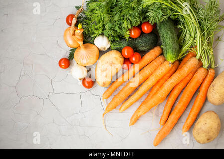Organic vegetables harvest with carrots, tomatoes, cucumbers , onions, potatoes on gray background, top view Stock Photo