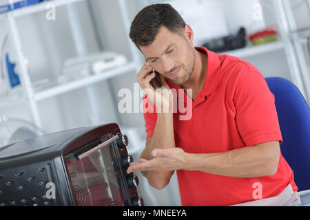 Man calling for support to repair electrical appliance Stock Photo