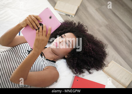Hispanic Girl Using Digital Tablet For School Homework Stock Photo
