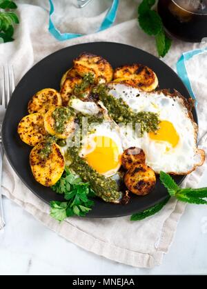 Fried eggs with plantain and chimichurri sauce for breakfast Stock Photo