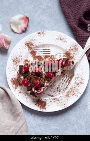 Tiramisu with cherry and chocolate on a white plate Stock Photo