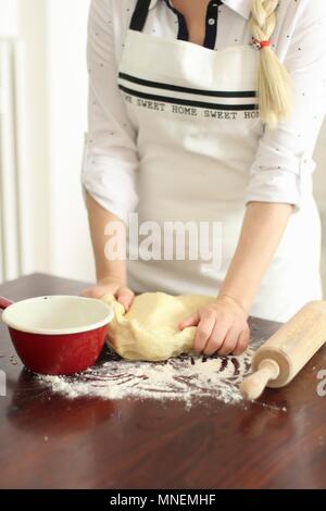 Woman Kneading Dough on Floured Counter in Kitchen Stock Photo