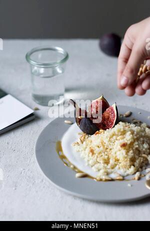 Lemon couscous with coconut yoghurt, figs and pine kernels Stock Photo