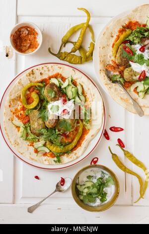 Vegetarian kofta with harissa, yoghurt, cucumber, coriander and hot green peppers on a tortilla Stock Photo