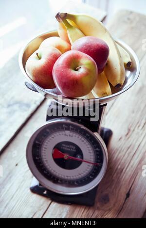 Apples and bananas on a pair of kitchen scales Stock Photo