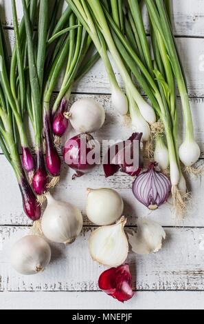 Red and white onions on a white wooden table Stock Photo