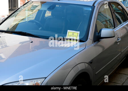 Parking penalty charge notice under car windshield wipers Stock Photo