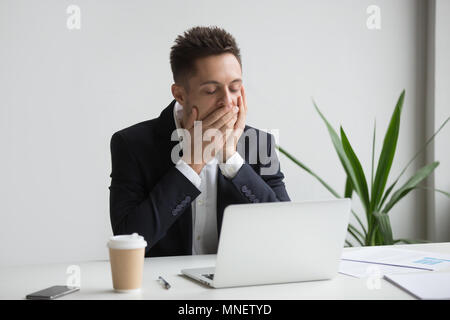 Tired office worker yawning working long hours Stock Photo