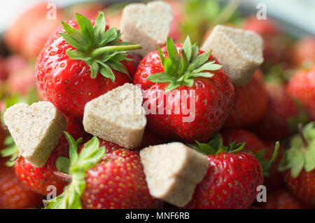 Juicy ripe berry red strawberry with chunks of cinnamon sugar in the shape of hearts Stock Photo