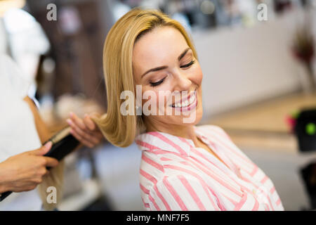 Hairdresser doing haircut for women in hairdressing salon. Stock Photo