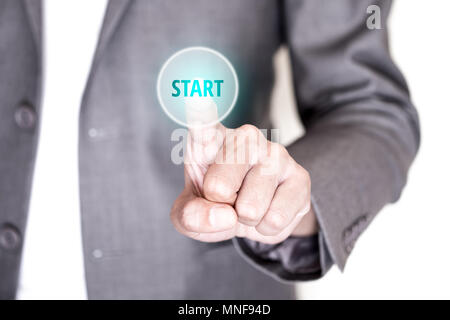Businessman in gray suit pushing start button on touch screen interface to begin his business and success. Stock Photo