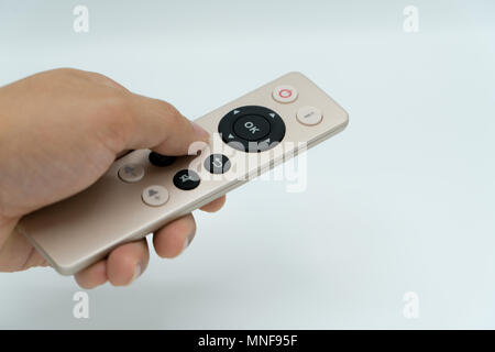 isolate hand control the TV/Media remote control gold color Stock Photo