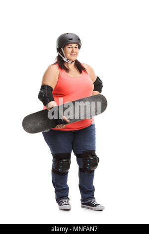Full length portrait of an overweight woman wearing protective gear holding a skateboard isolated on white background Stock Photo