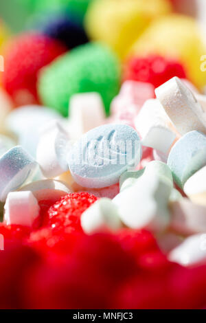 Sweet pills and drops in vibrant various colours. Selective focus on oval shape pill. Full frame background Stock Photo